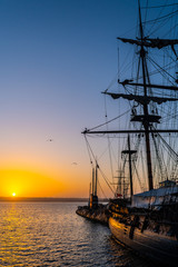 HMS Surprise ship, a tall modern replica of HMS Rose docked at Maritime Museum on the waterfront harbor bay in San Diego, Southern California at sunset.