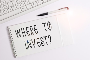 Conceptual hand writing showing Where To Invest question. Concept meaning asking about actions or process of making more money White pc keyboard with note paper above white background