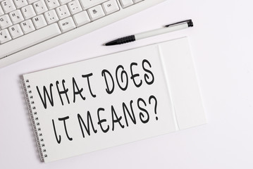 Conceptual hand writing showing What Does It Means question. Concept meaning asking someone about meaning you do not understand White pc keyboard with note paper above white background