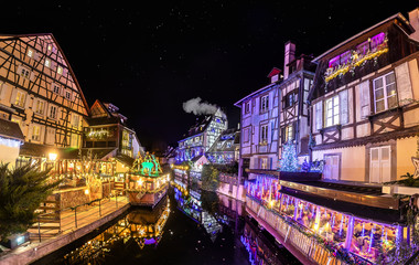 Fototapeta na wymiar Panorama of traditional Alsatian half-timbered houses and river Lauch in Petite Venise or little Venice, old town of Colmar, decorated and illuminated at christmas time, Alsace, France