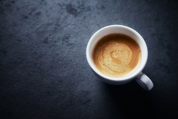 Obraz na płótnie Canvas Cup of coffee on dark stone background. Close up. Copy space