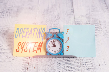 Conceptual hand writing showing Operating System. Concept meaning software that supports a computer s is basic functions Mini blue clock standing above buffer wire between two paper