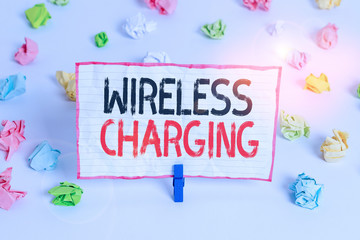 Handwriting text writing Wireless Charging. Conceptual photo methods of charging batteries without the use of cables Colored crumpled papers empty reminder white floor background clothespin