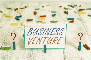 Conceptual hand writing showing Business Venture. Concept meaning new business that is formed with a plan and expect gain Crumbling sheet with paper clips placed on the wooden table