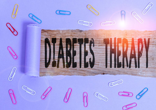 Conceptual hand writing showing Diabetes Therapy. Concept meaning aim to achieve lower average blood glucose results Paper clip and torn cardboard on wood classic table backdrop