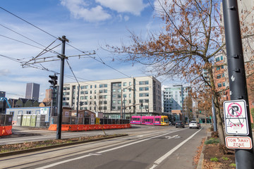The street car and other cars driving on a typical street in downtown Portland, Oregon in spring.