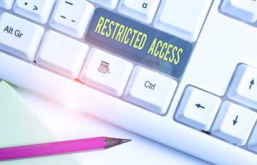 Conceptual hand writing showing Restricted Access. Concept meaning A class of service in which users may be denied access White pc keyboard with note paper above the white background