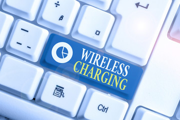 Word writing text Wireless Charging. Business photo showcasing methods of charging batteries without the use of cables White pc keyboard with empty note paper above white background key copy space