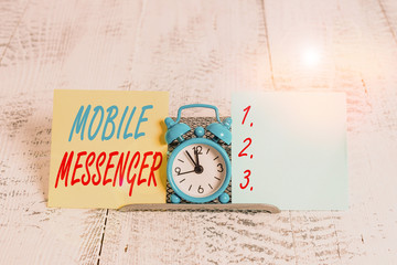 Conceptual hand writing showing Mobile Messenger. Concept meaning mobile tool that allows users to send chat messages Mini blue clock standing above buffer wire between two paper