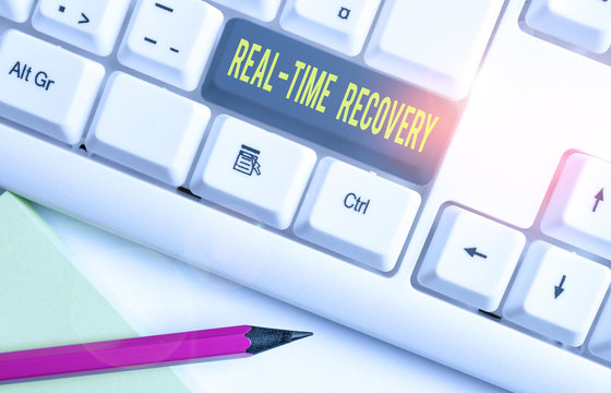 Conceptual hand writing showing Real Time Recovery. Concept meaning maximum time period in which recent data can recover White pc keyboard with note paper above the white background