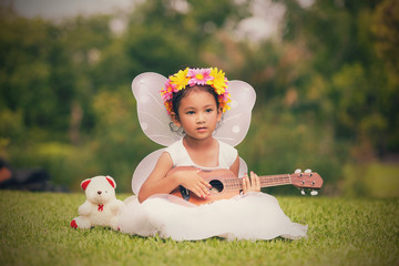 Beautiful asian girl playing ukulele, Outdoor portrait