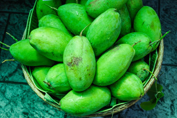 Fresh mangoes are put in a rattan basket.