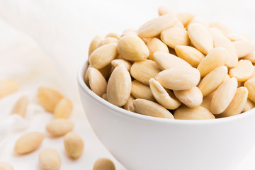 Bowl of almonds on a white background