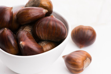 Bowl of chestnuts on a white background