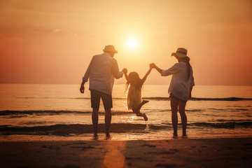 Summer vacation, Happy family jumping together on the beach in holiday.