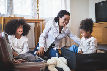 Travel and single mom concept, Single mother is packing luggage with children in the house.