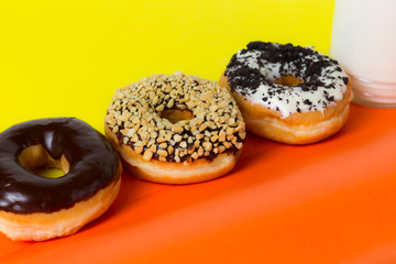 three glazed donuts with yellow and orange background