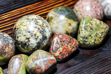 Collection of processed stones of different colors - magmatites - on a wooden background