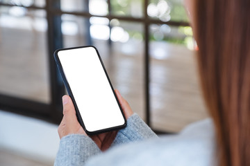 Mockup image of a woman holding black mobile phone with blank desktop screen