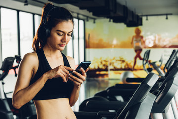 Beautiful woman using mobile smartphone during workout