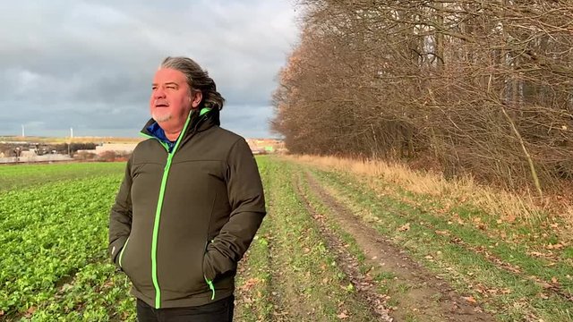 Slow motion of man losing his hat with the blow of high winds in a cold and windy winter afternoon.
