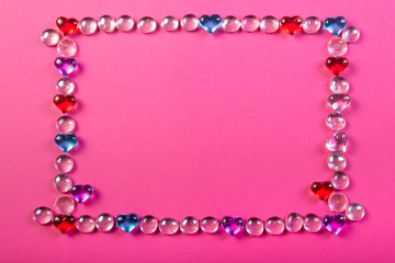 Obraz premium Frame for Valentine's day on a pink background made of pebbles in the shape of a heart.