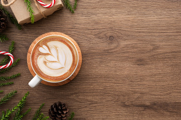 Wood table with cup of latte coffee and Christmas decoration with gift box. Christmas and new year...