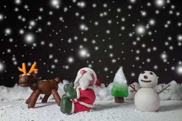 Cartoon character for Christmas season on background is dark with snow at nitght.