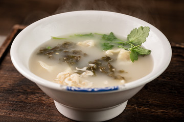 Shrimp wonton with braised pork in soup on wooden table / Select focus image...