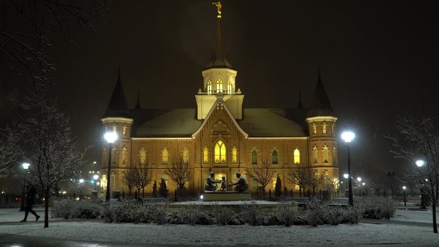 View of Temple in Provo Utah at night as snow falls during storm in late winter.