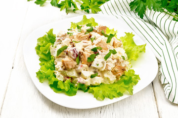 Salad of salmon and cucumber in plate on wooden board