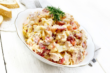 Salad with chicken and vegetables in plate on light board