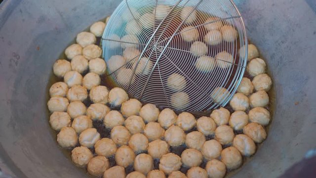  Fry meatballs in a frying pan street food in thailand.