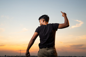 man turn back and pointing up in the sky