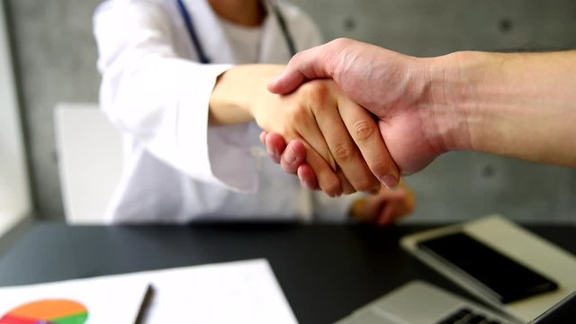 握手をする白衣を着た女性