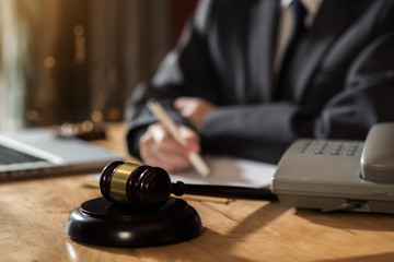 Justice and law concept. Female judge in a courtroom with the gavel working with digital tablet computer docking keyboard on wood table.