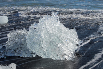large pieces of iceburg on black sand beach in Iceland
