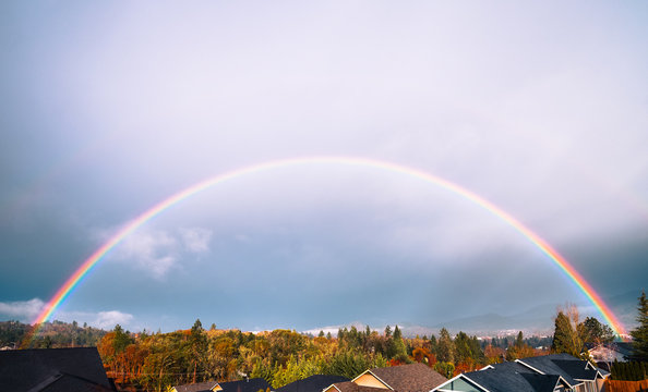 Full rainbow over neighborhood rooftops in southern Oregon