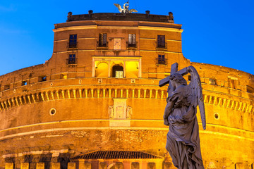 Italy, Rome: statue of an angel with a cross on the background of the castle of the Holy Angel.