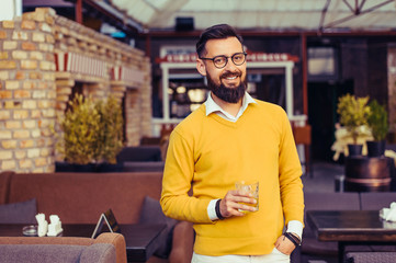 Fototapeta premium Handsome young man drinking an alcoholic drink in a restaurant