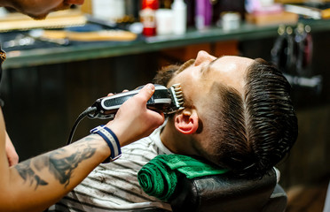A man in a barbershop caring for his beard