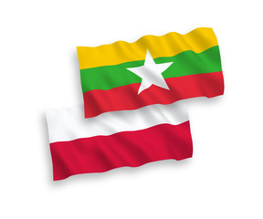 National vector fabric wave flags of Myanmar and Poland isolated on white background. 1 to 2 proportion.
