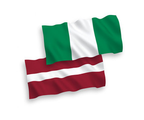 National vector fabric wave flags of Latvia and Nigeria isolated on white background. 1 to 2 proportion.
