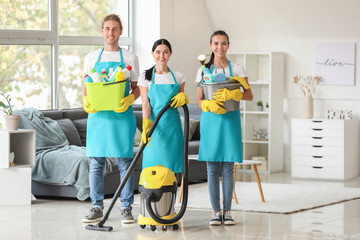 Team of janitors with cleaning supplies in flat