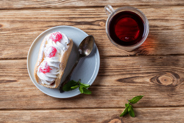 air cake on a saucer, hot tea on a wooden background