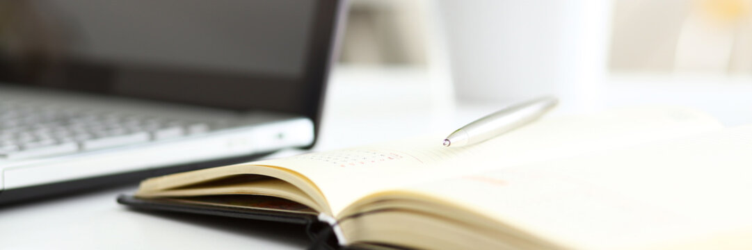 Silver pen lying on opened notebook sheet closeup - Powered by Adobe