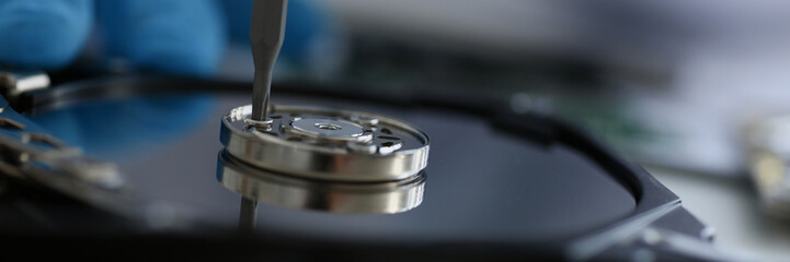 Male repairman wearing blue gloves dismantles specialized