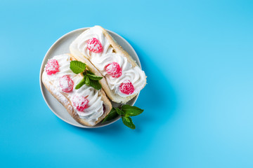 Cake with raspberries and sprinkles on a blue background