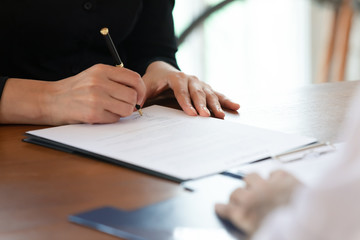 Close up cropped image young woman signing business agreement.