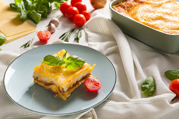 Plate with tasty baked lasagna on table